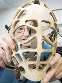  ??  ?? Bob Kelly shows off a vintage goalie mask, which he bought in the early 1960s and now hangs on the wall of his shop. To many, Kelly is the go-to guy in Ottawa for patching up worn-out or broken sporting gear.