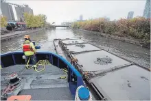  ?? BERNARD WEIL TORONTO STAR ?? A tugboat tows a scow filled with material dredged from the bottom of the Don River toward Toronto Harbour in November.