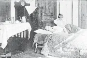  ?? [PHOTO PROVIDED BY LIBRARY OF CONGRESS/AP] ?? In this November 1918 photo made available by the Library of Congress, a girl stands next to her sister lying in bed. The girl became so worried she telephoned the Red Cross Home Service, who came to help the woman fight the influenza virus.