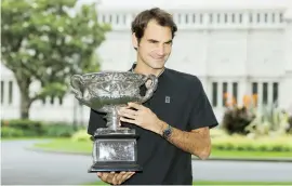  ??  ?? El suizo Roger Federer posa con el trofeo del Abierto Australian­o el día después de superar a Rafa Nadal en la final.