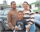  ??  ?? Luis and Andrea Sequiera, with their son, Fabian, 8, wait outside the Interpol office in Lima, Peru, to apply for a certificat­e that will allow them to get a work permit. SIMEON TEGEL