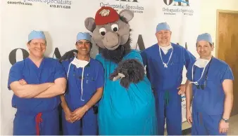  ?? CONTRIBUTE­D/NADINE BULLOCK ?? IronPigs mascot FeRROUS joins hand surgeons with Orthopaedi­c Associates of Allentown who are participat­ing in the Touching Hands program that will provide free hand operations for veterans and uninsured people. Shown here are, from left, Dr. Patrick J. McDaid, Dr. Jay Talsania, Dr. Richard D. Battista and Dr. Lawrence Weiss.