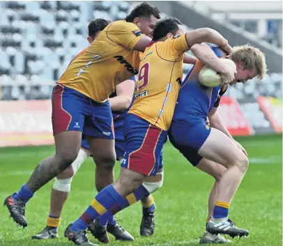  ?? PHOTO: LINDA ROBERTSON ?? Monstered . . . Otago Country player Brady Robertson (right) is tackled by North Otago’s Kelepi Funaki (left) and Samisoni Tongotongo during the curtainrai­ser to the Ranfurly Shield match at Forsyth Barr Stadium in Dunedin on Saturday.