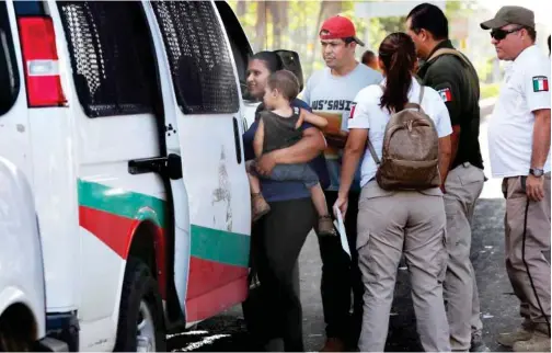  ??  ?? A migrant woman and her child are detained by Mexican immigratio­n agents at a checkpoint in Tapachula, Mexico.