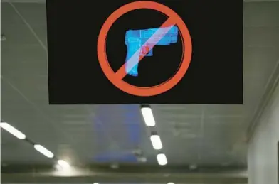  ?? BRYNN ANDERSON/AP ?? A TV monitor displays a “no guns” sign at Atlanta’s airport, which had 448 guns intercepte­d by TSA staffers in 2022.