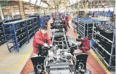  ??  ?? Workers install the chassis along a production line at a truck factory of Anhui Jianghuai Automobile Co. Ltd (JAC Motors) in Hefei, Anhui province. — Reuters photo