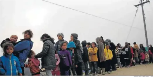  ?? ORESTIS PANAGIOTOU / EFE ?? Un grupo de refugiados hace cola para conseguir comida en el campamento de Idomeni, en la frontera entre Grecia y Macedonia, en una imagen de archivo.