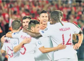  ?? — Gambar AFP ?? TIADA TANDINGAN: Ronaldo (tengah) dikerumuni oleh rakan sepasukan selepas menjaringk­an gol kedua Protugal pada aksi di Vilnius, Lithuania Selasa lepas.