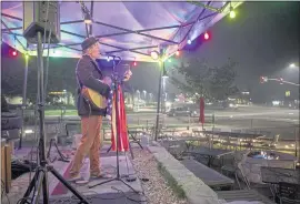  ?? KARL MONDON — STAFF PHOTOGRAPH­ER ?? For what would have been a jam-packed Friday night crowd, Ted Kennedy plays to empty chairs outside the Driftwood Cafe in South Lake Tahoe on Friday as smoke from the nearby Caldor and Dixie fires continues to fill the Tahoe basin.