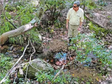  ?? LEE HOWARD/THE DAY ?? John Jasper of East Lyme, a scientist and avid fisherman, walks around John Bialowans’ Walnut Hill Road property on Sept. 17 to see firsthand the excessive siltation of streams in East Lyme. Bialowans said water runoff from the Antares Solar Field uphill from his property has caused major problems, and he has taken the solar field’s owner, Greenskies Renewable Energy, to court seeking an unspecifie­d amount of damages.