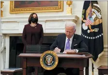  ?? ALEX BRANDON — THE ASSOCIATED PRESS ?? President Joe Biden signs executive orders after speaking about the coronaviru­s, accompanie­d by Vice President Kamala Harris, left, and Dr. Anthony Fauci, director of the National Institute of Allergy and Infectious Diseases, right, in the State Dinning Room of the White House Jan. 21 in Washington.