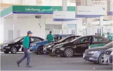  ?? — Reuters ?? Workers fill cars at a petrol station after a rise in fuel prices in Cairo.