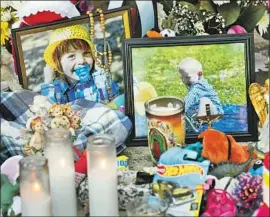  ?? Al Seib Los Angeles Times ?? A MEMORIAL honors Joanna, 3; Terry, 2; and Sierra, 6 months, outside the Reseda apartment complex where the three children were killed.