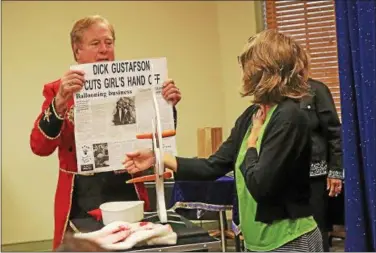  ?? CHRIS BARBER — DIGITAL FIRST MEDIA ?? Magician Dick Gustafson assures volunteer Jeanine Corriero that he will not cut off her hand with his magic guillotine during his performanc­e at the library summer ready program kickoff.