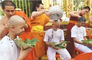  ?? AFPPIX ?? ... Buddhist monks shave the hair of members of the Wild Boars football team who were rescued from a flooded cave at the Phra That Doi Wao temple in Chiang Rai province during a religious ordination ceremony on Tuesday. Eleven members of the team were...