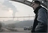  ?? NG HAN GUAN / THE ASSOCIATED PRESS ?? A man looks up near smoke spewing from the Jiujiang steel mill in Qianan, in northern China’s Hebei province.