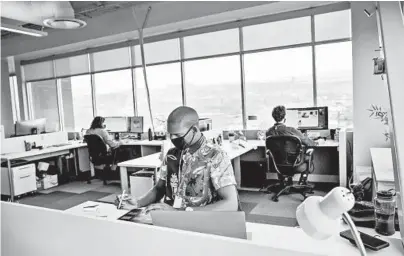  ?? KIM RAFF/THE NEW YORK TIMES ?? Employees with Vivint work at their office Feb. 16 in Lehi, Utah. The home security company is allowing 40% of its 4,000 Utah employees to return to the office voluntaril­y, though only about 20% have chosen to do so regularly.