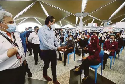  ?? (Foto Mohd Fadli Hamzah/bh) ?? Khairy beramah mesra dengan penerima vaksin ketika membuat tinjauan di Pusat Pemberian Vaksin Industri di KLIA, semalam.