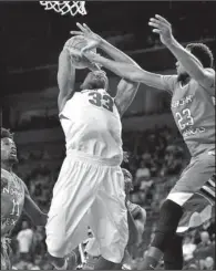  ?? NWA Media/BEN GOFF ?? Arkansas’ Moses Kingsley (middle) draws a foul from Jordan Williams (23) of North Texas as he attempts a shot during the first half of the No. 25 Razorbacks’ 89-73 victory Friday at Walton Arena in Fayettevil­le.