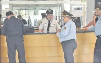  ??  ?? El jefe de Prevención y Seguridad de Asunción, comisario principal Carlos Aguilera, conversa con el guardia del edificio donde vivía el diputado Ulises Quintana.