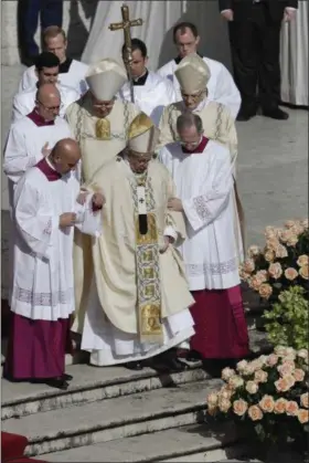  ?? GREGORIO BORGIA — THE ASSOCIATED PRESS ?? Pope Francis is helped by masters of ceremonies to walk down the steps as he arrives to celebrates the Easter mass in St. Peter’s Square at the Vatican, Sunday.