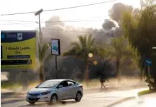  ?? THE ASSOCIATED PRESS ?? A Palestinia­n man runs for cover as smoke rises Saturday following an Israeli airstrike on a government­al building in Gaza City.