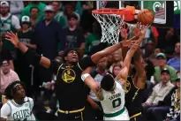  ?? ?? The Celtics’ Jayson Tatum (0) shoots the ball defended by the Warriors’ Kevon Looney (5) in the second quarter during Game 4of the NBA Finals at TD Garden on Friday in Boston.