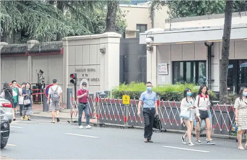  ?? AFP ?? People walk past the entrance of the US consulate in Chengdu, southwest China’s Sichuan province. China yesterday ordered the closure of the US consulate.