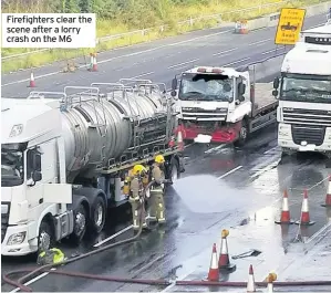  ??  ?? Firefighte­rs clear the scene after a lorry crash on the M6