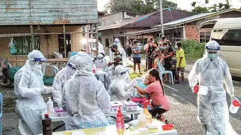  ??  ?? A Covid-19 swab team in the thick of action carrying out sampling at a longhouse in Sibu recently.