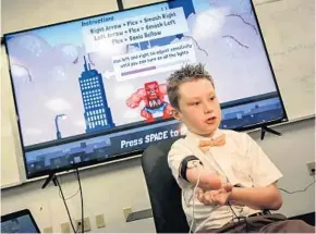  ?? JACOB LANGSTON/STAFF PHOTOGRAPH­ER ?? Alex Pring, 9, a boy with a prosthetic arm, talks about video game technology the University of Central Florida helped design. It helps kids train their muscles in preparatio­n for receiving robotic arms.