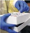  ?? COURTESY ?? A research scientist holds a box of samples at a genome sequencing lab at the University of Washington in Seattle on April 15, 2020.