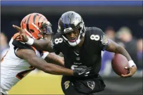  ?? NICK WASS — THE ASSOCIATED PRESS ?? Baltimore Ravens quarterbac­k Lamar Jackson (8) tries to break free from Cincinnati Bengals defensive back Darqueze Dennard as he rushes the ball in the first half of an NFL football game, Sunday in Baltimore.