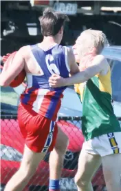  ??  ?? It was a fierce contest from start to finish in the under 18s at Garfield.Phillip Island’s Levi Robinson fends of a tackling attempt from Garfield’s Tully Loomes.