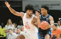  ?? MARTA LAVANDIER/AP ?? Duke guard Jeremy Roach looks to pass the ball under pressure from Miami forward Norchad Omier during the Hurricanes’ win over the Blue Devils on Monday in Coral Gables.