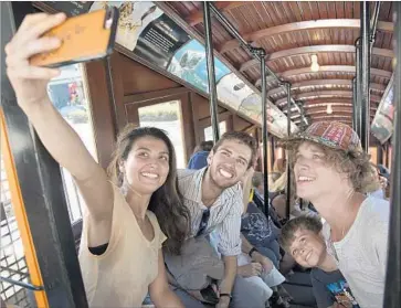  ?? Photograph­s by Myung J. Chun Los Angeles Times ?? KRISTINE SMITH, left, Mathew Krogen, Matthew Eppes and Bobby Crissy capture their Angels Flight ride on Thursday. The railway, which spans nearly 300 feet, was recently featured in the film “La La Land.”