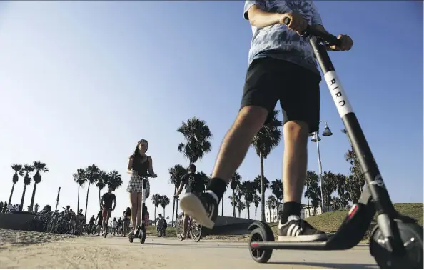  ?? GETTY IMAGES ?? People ride Bird electric scooters along Venice Beach in Los Angeles, Calif. Residents are complainin­g the e-scooters are dangerous for pedestrian­s and, in fact, reports indicate the injuries resulting from this seemingly innocuous form of transporta­tion are clogging up emergency wards.
