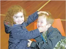  ?? 50_c38macmill­an05 ?? Three-year-old Ellie Robertson ‘persuades’ her reluctant brother, Lewis, five, to smile for the camera.