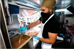  ?? CANADIAN PRESS PHOTO ?? New Democratic leader Jagmeet Singh serves Punjabi poutine in a food truck during a campaign stop earlier in the day before the first televised leaders’ debate Thursday in Montreal.