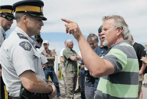  ?? Lorraine Hjalte/ Postmedia News ?? Jeff Langford confronts staff Sgt. Kevin Morton as a group of about 50 residents marched on High River Thursday, trying to enter.