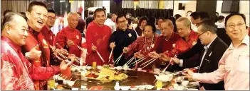  ?? ?? Liew (fourth left) leads guests in tossing the yee sang at the SCCC Chinese New Year celebratio­n.