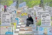  ??  ?? A woman in Syria’s Qamishli town looks on as she sits among graves at a cemetery after the burial of Kurdish fighters killed during clashes in the northeaste­rn Syrian town of Ras al-ayn. REUTERS