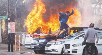  ??  ?? Un manifestan­te destruye un auto incendiado durante las protestas de ayer en el balneario Viña del Mar, donde arrancó el festival internacio­nal más importante de Latinoamér­ica.