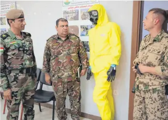  ?? FOTO: LUDGER MÖLLERS ?? Zwei kurdische Peschmerga-Offiziere bei der Ausbildung durch den deutschen Hauptfeldw­ebel Rene H. (rechts) für den Kampf gegen chemische Waffen, die die Terrormili­z IS bereits eingesetzt hat.