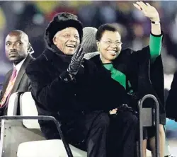  ??  ?? Former South African President, Nelson Mandela (left), and his wife, Graca Machel (right), wave to spectators as they are driven across the field during the closing ceremony before the World Cup final match between the Netherland­s and Spain at Soccer...