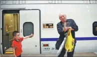  ?? ZOU HONG / CHINA DAILY ?? A passenger takes a photo of his grandson at Beijing South Railway Station on Thursday before they board a bullet train heading to Baigou in Hebei province.