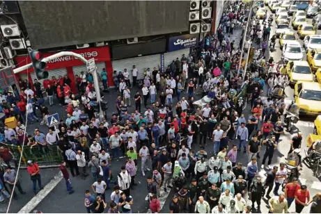  ?? (ATTA KENARE/AFP) ?? A Téhéran, des commerçant­s du Grand Bazar s’élevaient en juin dernier contre la dégringola­de du rial sur le marché des changes. Désormais, les manifestat­ions se multiplien­t contre la chute du pouvoir d’achat des Iraniens.