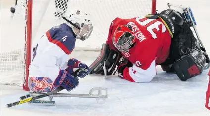  ?? LEAH HENNEL/ POSTMEDIA NEWS ?? Brody Roybal, left, of the U. S. sledge hockey team celebrates after getting a shot past Team Canada goalie Corbin Watson in the Americans’ semifinal win in Sochi on Thursday.
