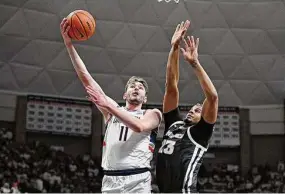  ?? Jessica Hill/Associated Press ?? UConn's Alex Karaban (11) shoots around Providence's Bryce Hopkins (23) on Feb. 22 in Storrs.