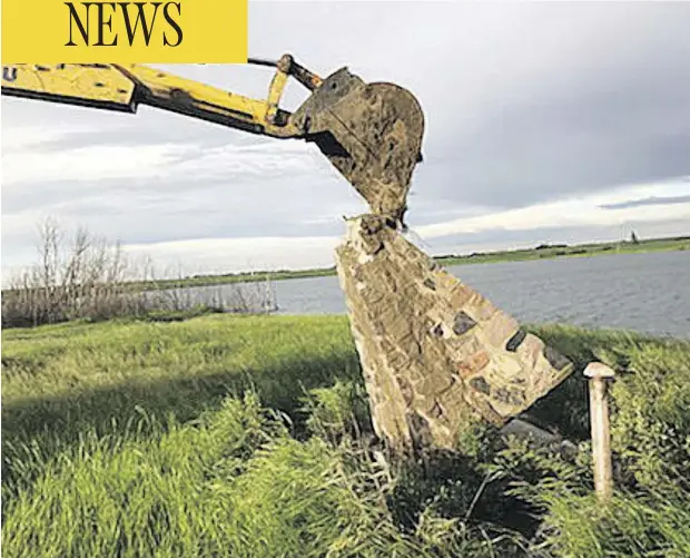  ?? PHOTOS:THE CANADIAN PRESS/HO/VILLAGE OF ALVENA ?? After initial efforts using a hammer and chisel failed, a backhoe was called in to find a time capsule thought to be hidden inside this cairn erected in 1968 on a Saskatchew­an village’s waterfront. Opening the capsule was supposed to be the highlight...